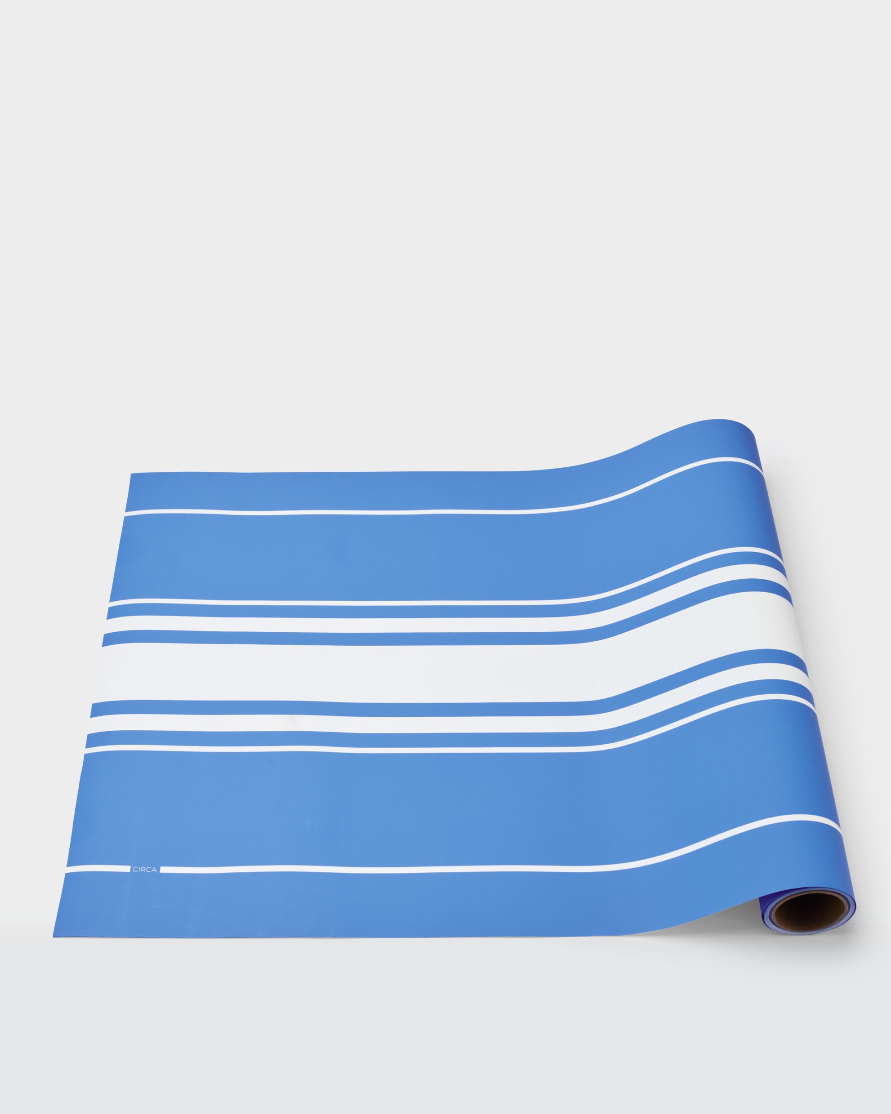 Summer paper table runner with white stripes on a blue background.