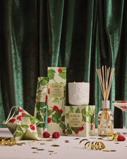 Raspberry & Rhubarb Christmas candle, diffuser, Scent Stems and bauble gift packaging styled against green velvet.